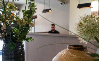 réceptionniste derrière son comptoir qui travaille au masq hôtel best western premier à la rochelle