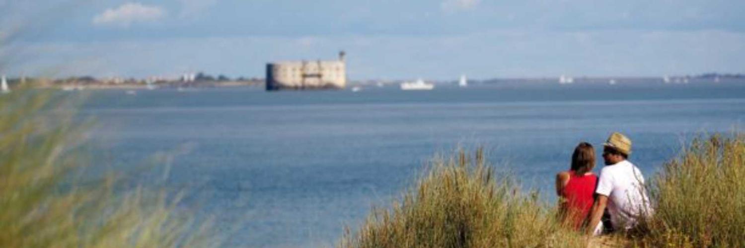 couple en bord de mer qui regarde le fort boyard proche de nos hôtels à la rochelle