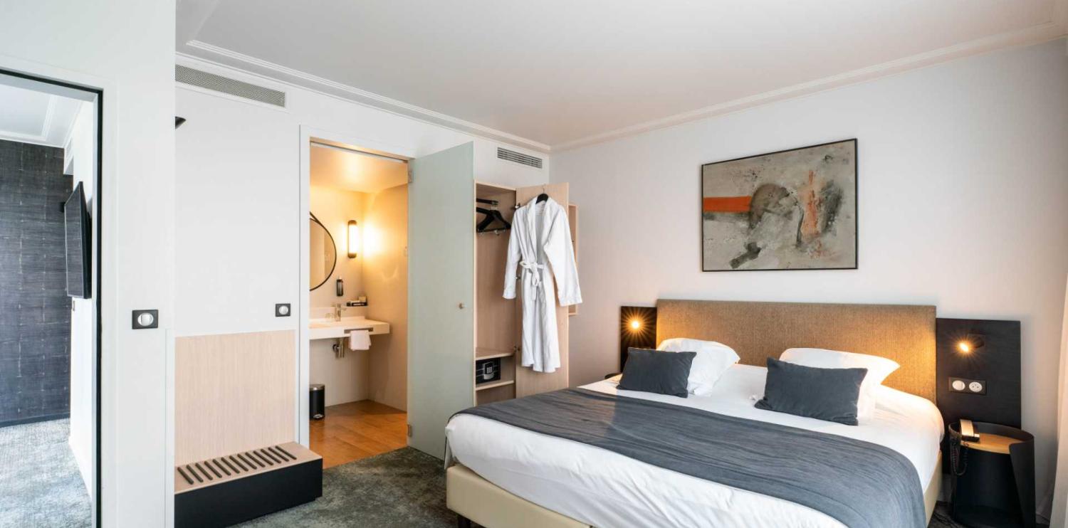 chambre d'hôtel lumineuse et spacieuse avec un grand lit, décorée dans un style contemporain