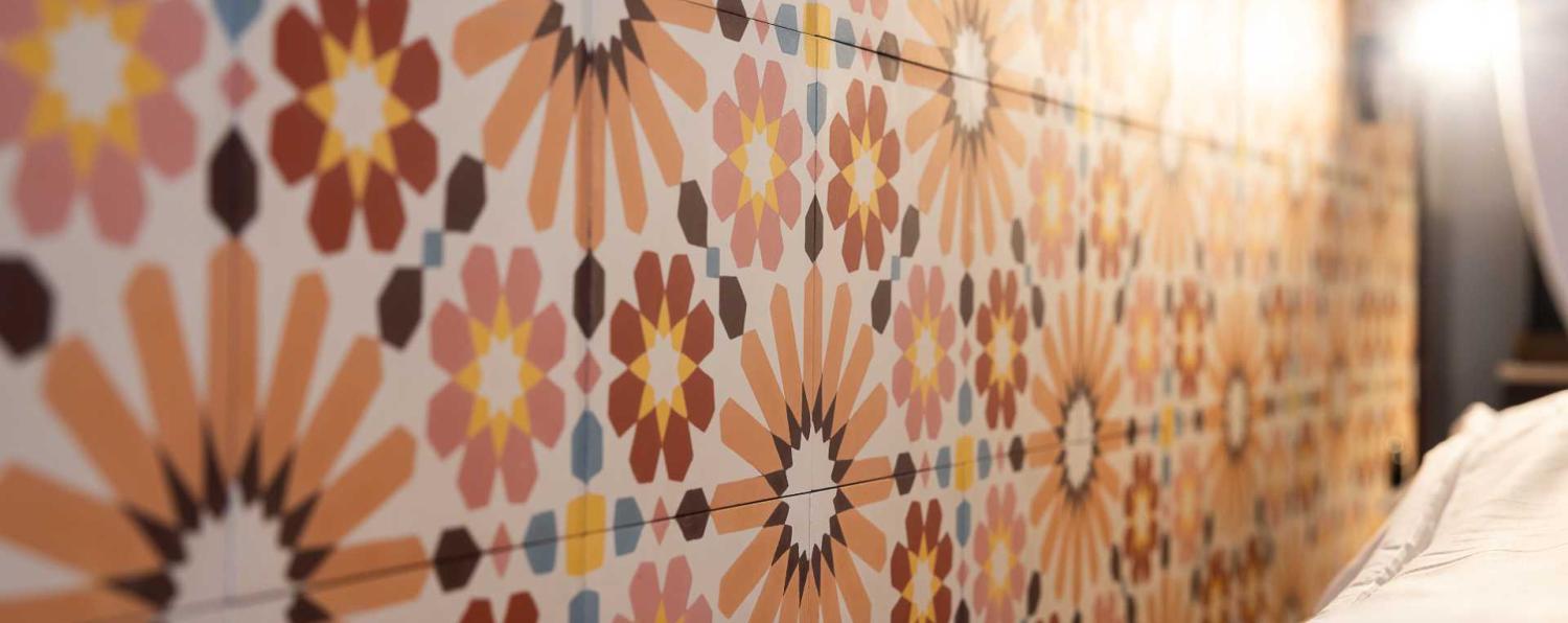 mur décoratif avec un motif géométrique floral coloré, illustrant le style artistique de l'hôtel