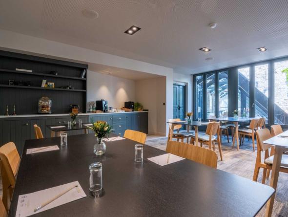 salle avec plusieurs tables et chaises de notre hotel seminaire la rochelle