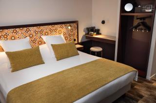 chambre confortable avec lit double, motifs floraux sur la tête de lit et mobilier moderne